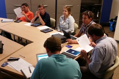 Folks at a table with paper forms and iPad versions