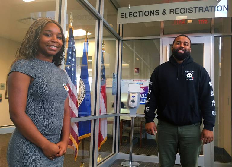 Two young poll managers pose for a photo in the elections office.