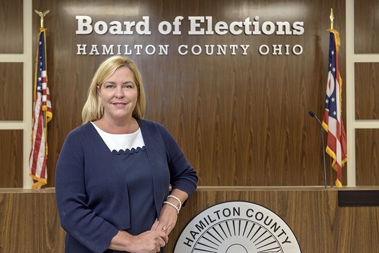 A woman stands in front of a wall with a sign that says "Board of Elections Hamilton County Ohio"