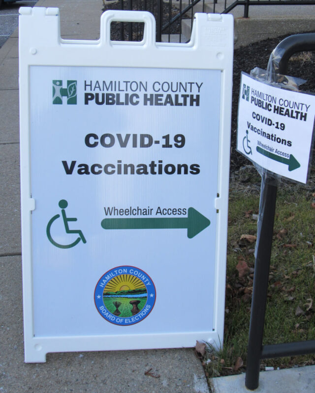 A sign with an arrow that says "COVID-19 Vaccinations"