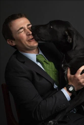 a photo of a man and a dog licking his face