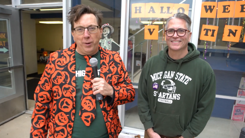 Two people—one dressed up in a Halloween suit—pose for the camera.